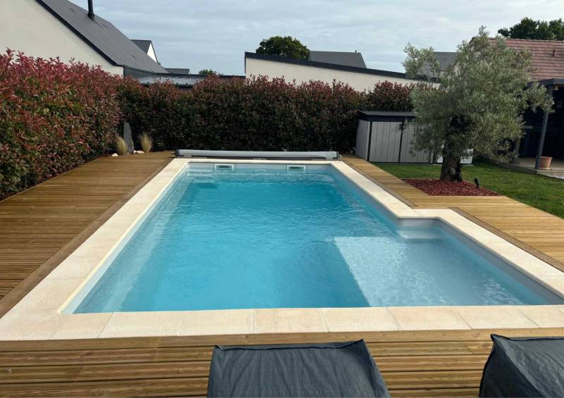 vue en longueur Piscine avec margelles sur terrasse planchée
