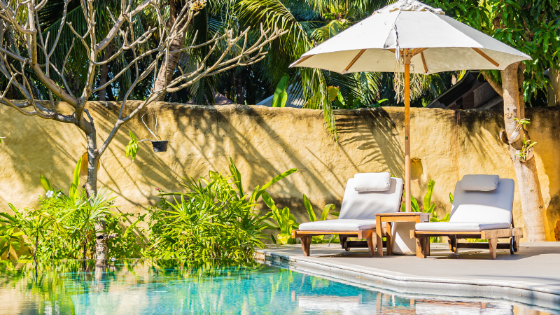 Aménagement paysager autour d’une piscine coque polyester à Rocbaron : plage en bois, végétation méditerranéenne et mobilier de jardin pour créer un espace extérieur élégant et fonctionnel.