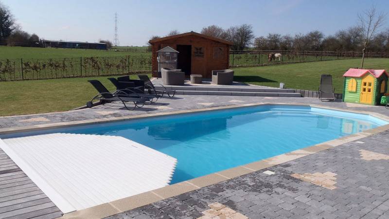 Piscine coque polyester AGATE 8 m : bassin rectangulaire avec pans coupés, fond incliné et banquette conviviale.