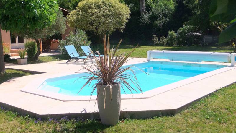 Piscine dans jardin avec enrouleur